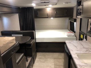 Interior view of a travel trailer, showcasing the layout and design of living spaces, including furniture and amenities